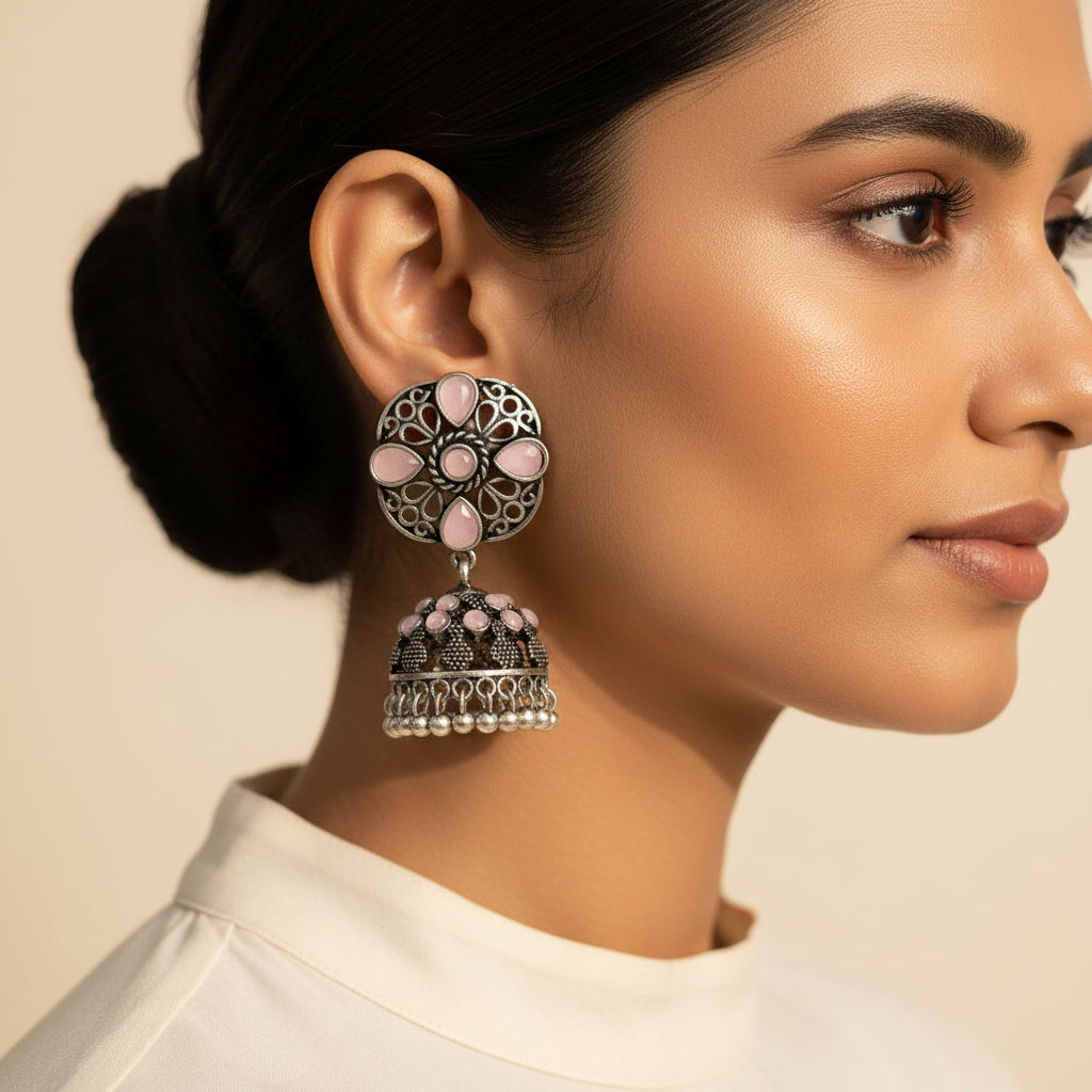 oxidized floral jhumka earrings with baby pink stone detailing.